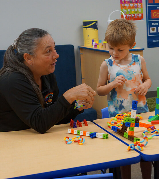 staff working with a child and toys